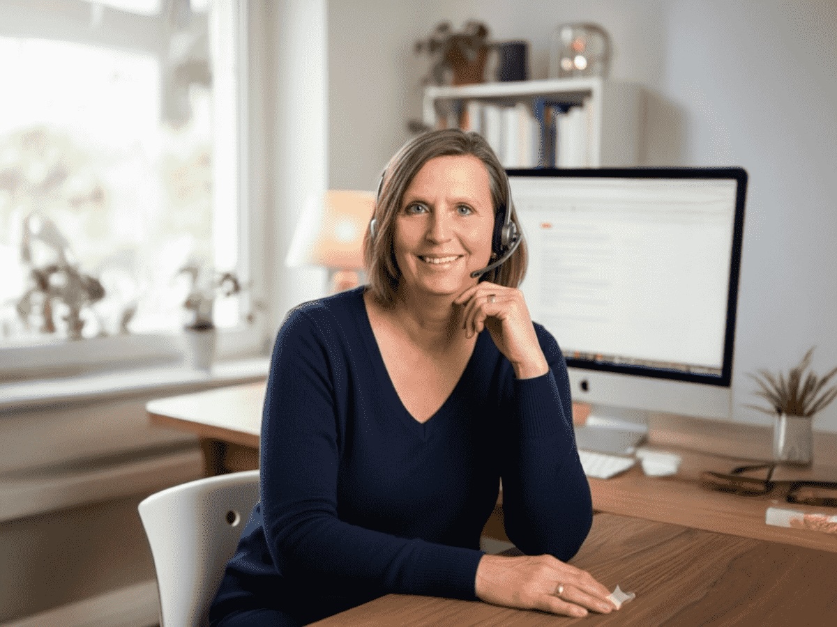 Beate Schranz mit Headset am Schreibtisch